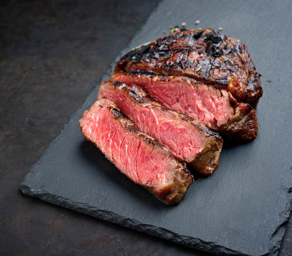 Medium-rare steak on a black stone plate